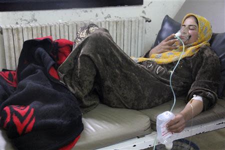 A woman, affected by what activists say was a gas attack, breathes through an oxygen mask inside a field hospital in Kfar Zeita village in the central province of Hama April 12, 2014. REUTERS/Stringer