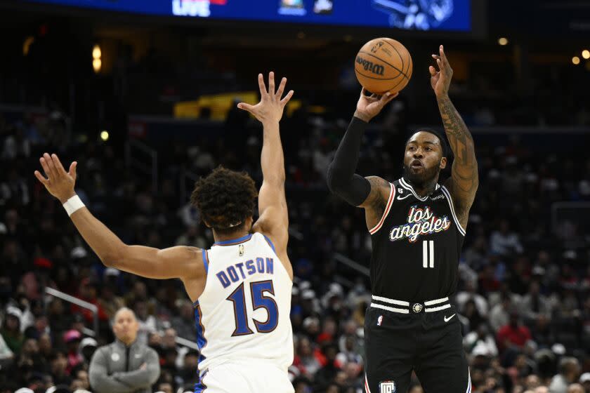 Los Angeles Clippers guard John Wall (11) shoots against Washington Wizards guard Devon Dotson (15) during the first half of an NBA basketball game, Saturday, Dec. 10, 2022, in Washington. (AP Photo/Nick Wass)