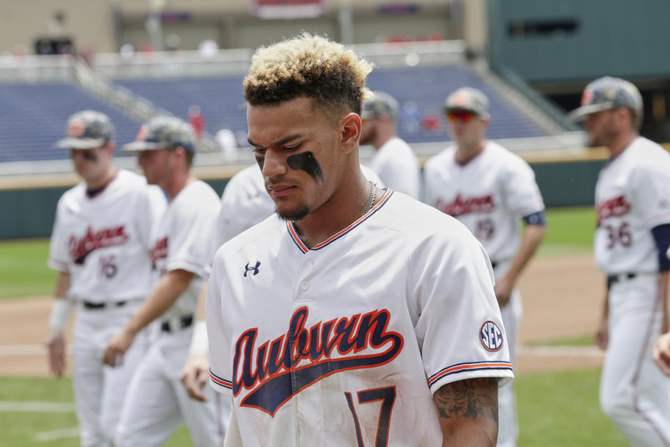 Auburn's Will Holland (17) and teammates walk off the field following their 5-3 loss to Louisville, in an NCAA College World Series elimination baseball game in Omaha, Neb., Wednesday, June 19, 2019. (AP Photo/Nati Harnik)