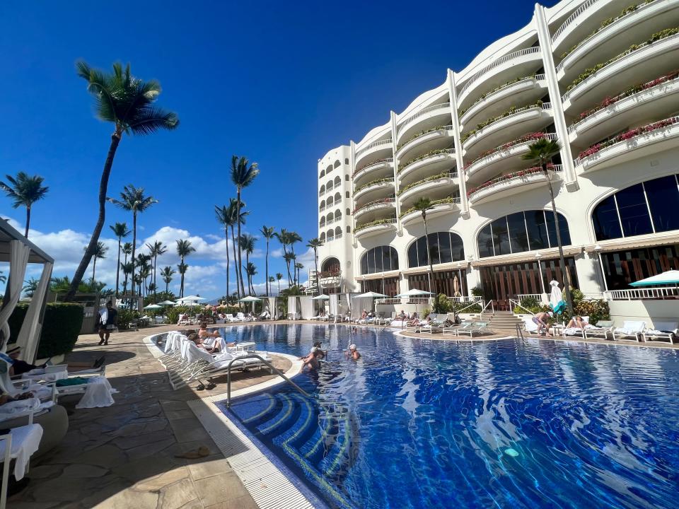 pool area with white hotel area overlooking