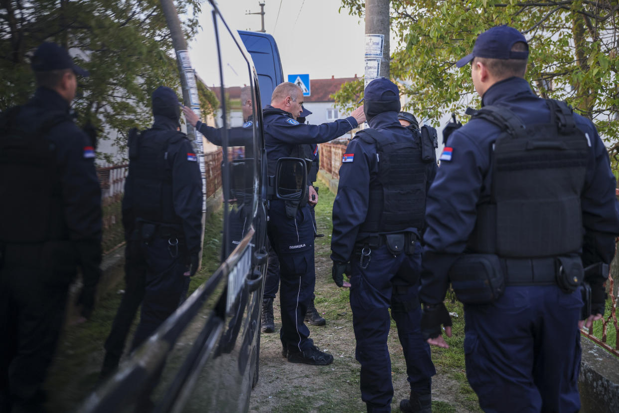 Police officers prepare for a chase in the village of Dubona, some 50 kilometers (30 miles) south of Belgrade, Serbia, Friday, May 5, 2023, near the scene of a Thursday night attack. A shooter killed multiple people and wounded more in a drive-by attack late Thursday in Serbia's second such mass killing in two days, state television reported. (AP Photo/Armin Durgut)