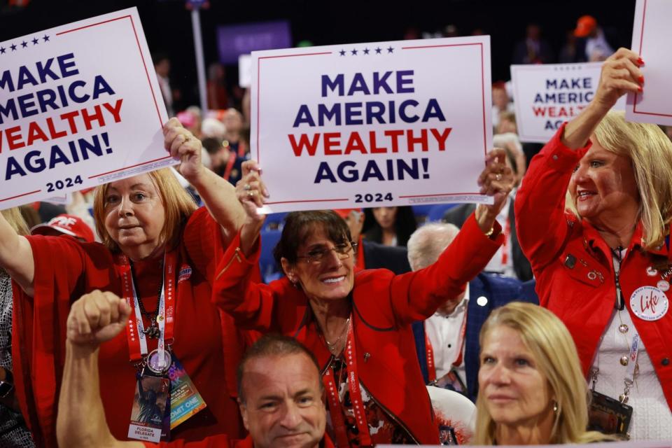 PHOTO: People hold signs with the theme of the evening session on the first day of the Republican National Convention, July 15, 2024, in Milwaukee. (Joe Raedle/Getty Images)