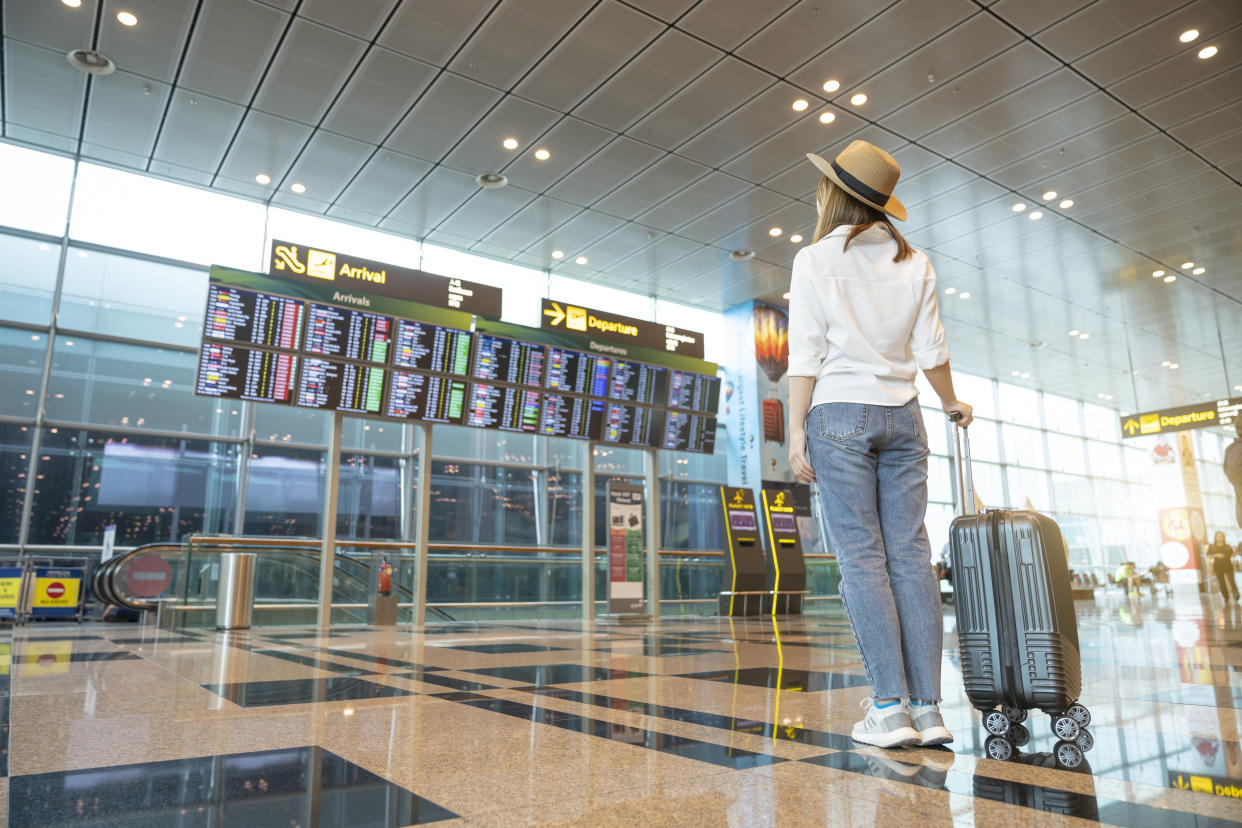 Rear tourist woman at international airport flight cancellation