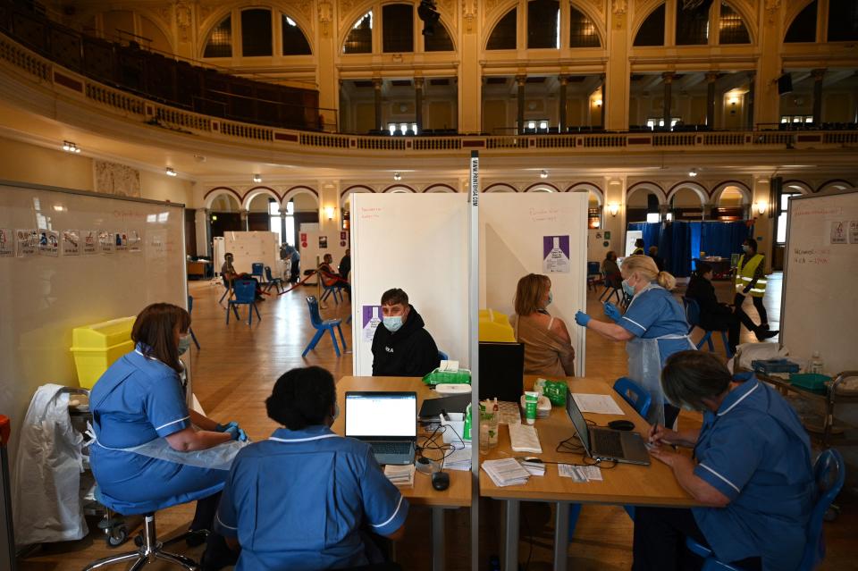A health worker injects a dose of the AstraZeneca/Oxford Covid-19 vaccine at a temporary vaccine centre set up at City Hall in Hull, northeast England on May 7, 2021. (Photo by Oli SCARFF / AFP) (Photo by OLI SCARFF/AFP via Getty Images)