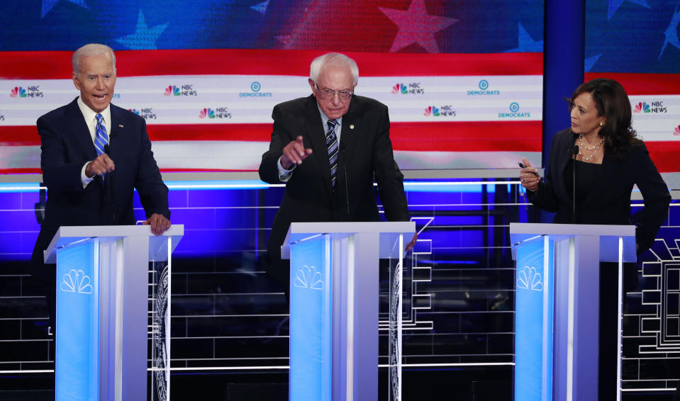 Democratic presidential candidate, former vice president Joe Biden, left, Sen. Bernie Sanders, I-Vt., and Sen. Kamala Harris, D-Calif., speak simultaneously during the Democratic primary debate at the Adrienne Arsht Center for the Performing Arts, Thursday, June 27, 2019, in Miami. (AP Photo/Wilfredo Lee)