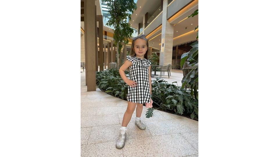 Ella Jordan posing in black and white gingham dress on holiday