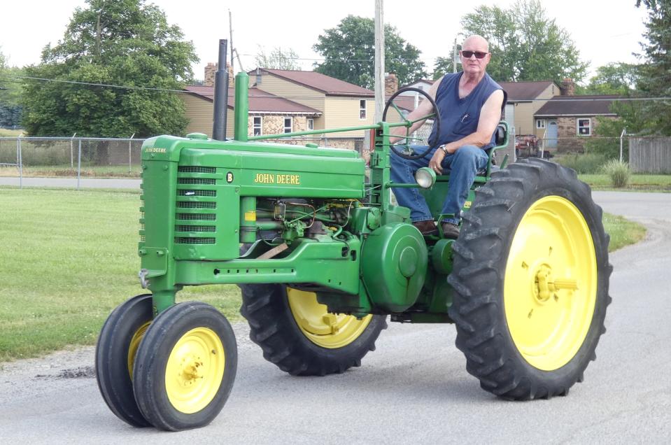Roger Haas rides his 1951 John Deere B tractor toward the Crawford Museum of Agriculture at the Crawford County Fairgrounds on Monday. The tractor will be on display during Crawford Antique Farm Machinery's 22nd annual show, which runs Thursday through Saturday.