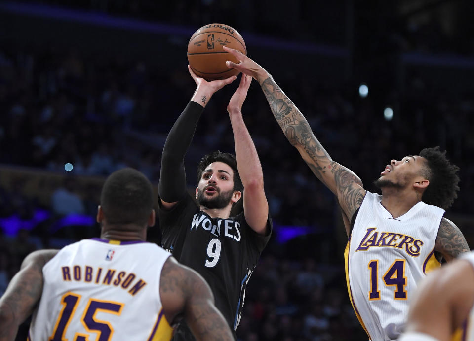 Minnesota Timberwolves guard Ricky Rubio, center, of Spain, shoots as Los Angeles Lakers forward Thomas Robinson and forward Brandon Ingram defend during the first half of an NBA basketball game, Sunday, April 9, 2017, in Los Angeles. (AP Photo/Mark J. Terrill)