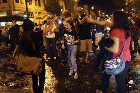 Fans celebrate on a street in the Mission District after the San Francisco Giants defeated the Kansas City Royals in Game 7 of the World Series, in San Francisco, California October 29, 2014. REUTERS/Robert Galbraith