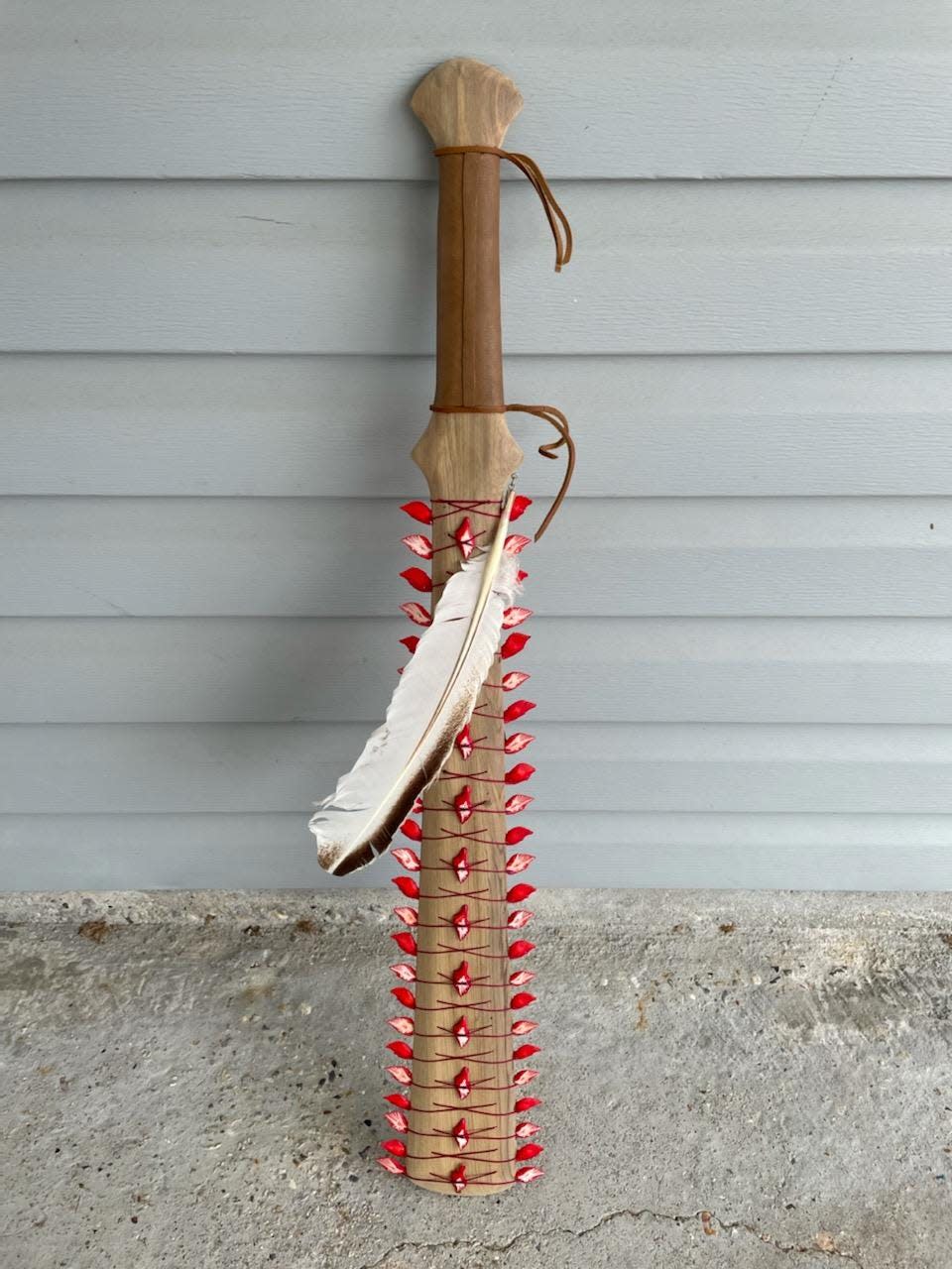 A war club created by Douglas P. Fazzio styled after the Maori clubs of Hawaii. Fazzio used the ganoid scales of the alligator garfish in the design.