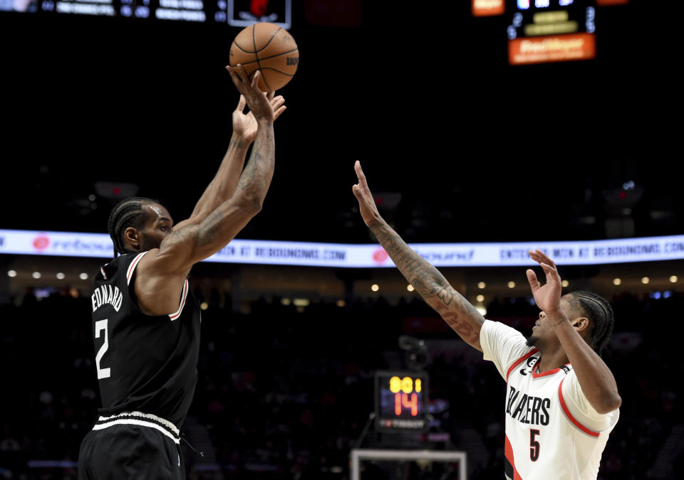 Los Angeles Clippers forward Kawhi Leonard shoots over Portland Trail Blazers forward Cam Reddish, right, during the second half of an NBA basketball game in Portland, Ore., Sunday, March 19, 2023. The Clippers won 117-102. (AP Photo/Steve Dykes)