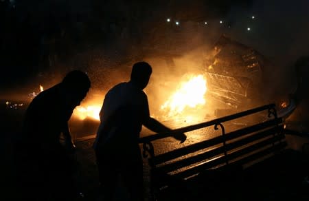 People extinguish a fire from a blast outside the National Cancer Institute, Cairo