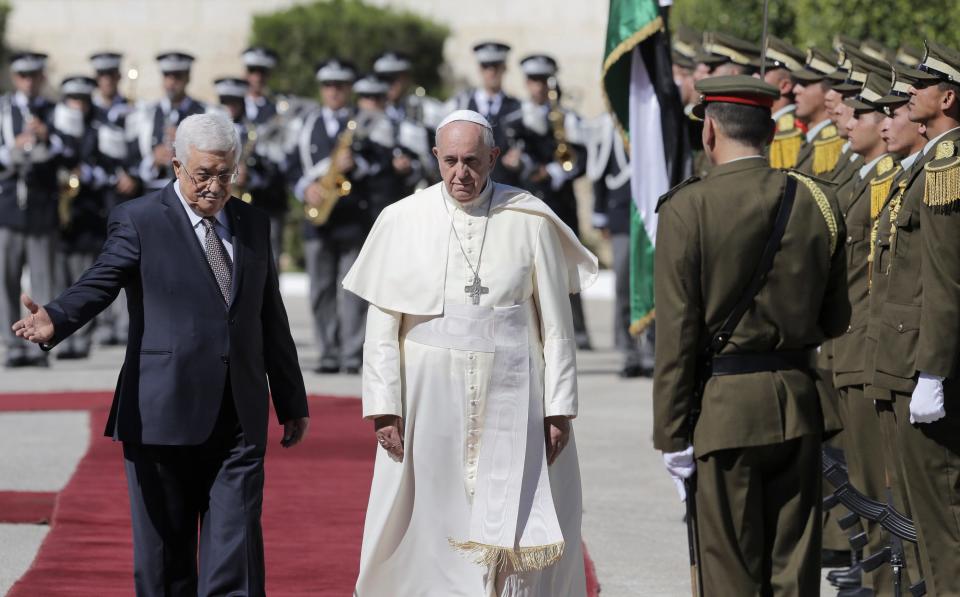 Pope Francis and Palestinian president Mahmoud Abbas review the honor guard upon Francis' arrival to the West Bank town of Bethlehem