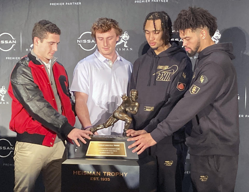 From left to right, Georgia quarterback Stetson Bennett, TCU quarterback Max Duggan, Ohio State quarterback C.J. Stroud and Southern California quarterback Caleb Williams pose with NCAA college football's Heisman Trophy in New York, Friday, Dec. 9, 2022. The four are finalists for the award that will be presented Saturday night. (AP Photo/Ralph Russo)