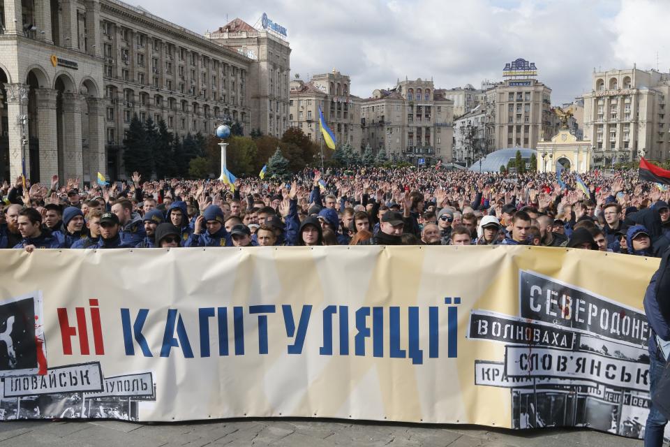 Protesters hold a banner that reads: "No Capitulation" as they gather in Independence Square in Kyiv, Ukraine, Sunday, Oct. 6, 2019. Thousands are rallying in the Ukrainian capital against the president's plan to hold a local election in the country's rebel-held east, a move seen by some as a concession to Russia. (AP Photo/Efrem Lukatsky)