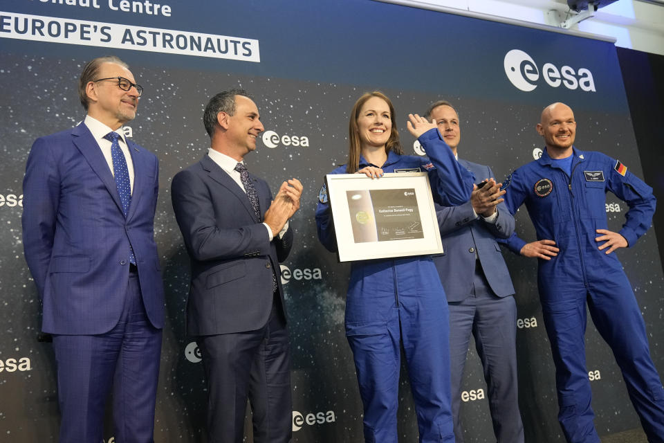 Katherine Bennell-Pegg of Australia waves as she shows her certificate at the candidates of the Class of 2022 graduation ceremony at the European Astronaut Centre in Cologne, Germany, Monday, April 22, 2024. ESA astronaut candidates Sophie Adenot of France, Pablo Alvarez Fernandez of Spain, Rosemary Coogan of Britain, Raphael Liegeois of Belgium and Marco Sieber of Switzerland took up duty at the European Astronaut Centre one year ago to be trained to the highest level of standards as specified by the International Space Station partners. Also concluding a year of astronaut basic training is Australian astronaut candidate Katherine Bennell-Pegg, who has trained alongside ESA's candidates. (AP Photo/Martin Meissner)