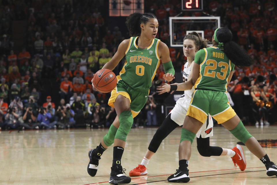 Oregon's Satou Sabally (0) drives to the basket around teammate Minyon Moore (23) and Oregon State's Kat Tudor (22) during the first half of an NCAA college basketball game in Corvallis, Ore., Sunday, Jan. 26, 2020. (AP Photo/Amanda Loman)