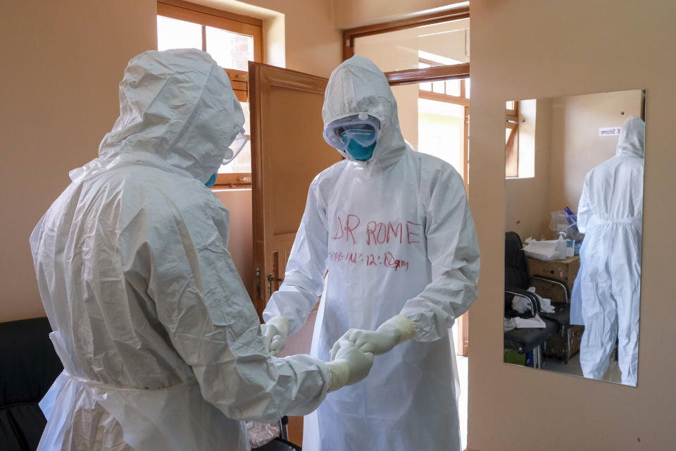 Doctors wearing protective equipment pray together before they visit a patient who was in contact with an Ebola victim, in the isolation section of Entebbe Regional Referral Hospital in Entebbe, Uganda Thursday, Oct. 20, 2022. Uganda's Ebola outbreak is "rapidly evolving" a month after the disease was reported in the country, a top World Health Organization official said Thursday, describing a difficult situation for health workers on the ground. (AP Photo/Hajarah Nalwadda)