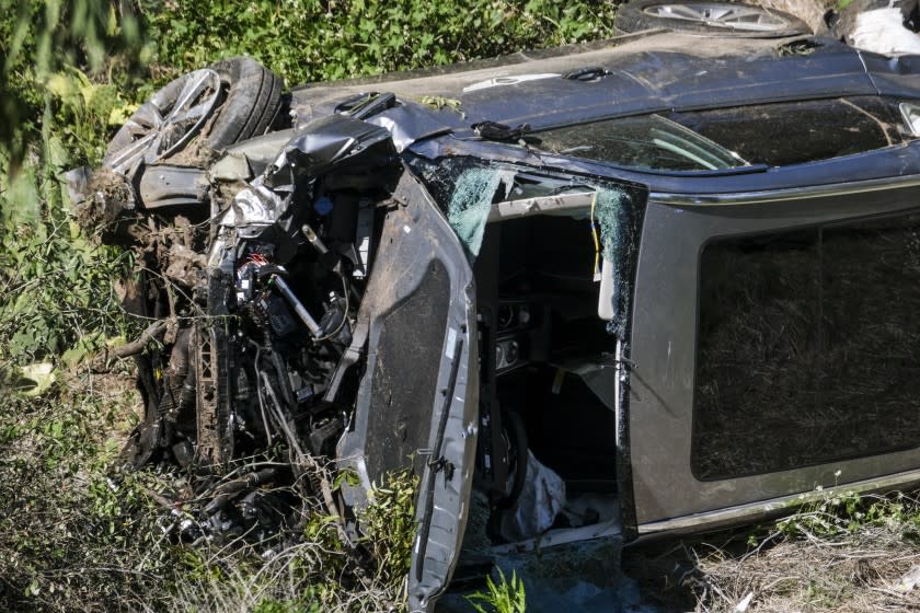 A vehicle rests on its side after a rollover accident involving golfer Tiger Woods along a road in the Rancho Palos Verdes suburb of Los Angeles on Tuesday, Feb. 23, 2021. Woods suffered leg injuries in the one-car accident and was undergoing surgery, authorities and his manager said. (AP Photo/Ringo H.W. Chiu)