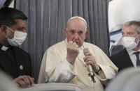 Pope Francis greets the journalists onboard the papal plane on the occasion of his five-day pastoral visit to Cyprus and Greece, Monday, Dec. 6, 2021. Francis' five-day trip to Cyprus and Greece has been dominated by the migrant issue and Francis' call for European countries to stop building walls, stoking fears and shutting out "those in greater need who knock at our door." (Alessandro Di Meo/Pool photo via AP)