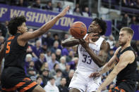 Washington forward Isaiah Stewart (33) loses the ball as he tries to shoot between Oregon State guard Ethan Thompson (5) and forward Tres Tinkle during the first half of an NCAA college basketball game Thursday, Jan. 16, 2020, in Seattle. (AP Photo/Ted S. Warren)