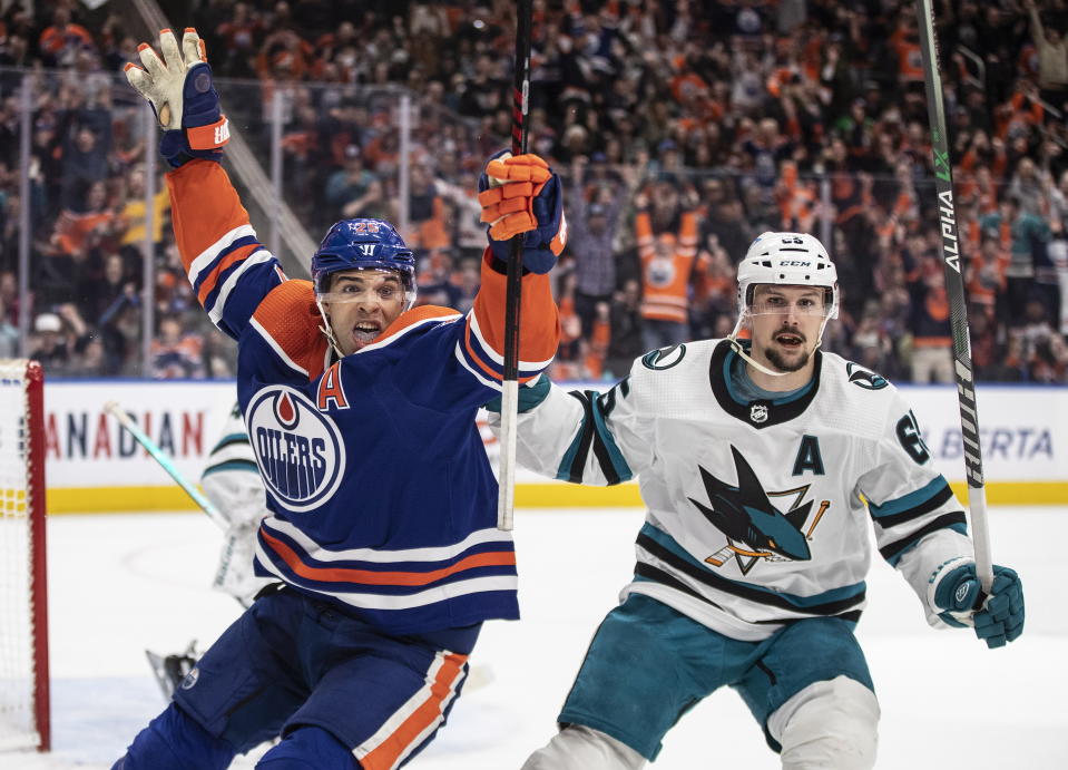 San Jose Sharks' Erik Karlsson (65) looks on as Edmonton Oilers' Darnell Nurse (25) celebrates a goal during overtime in an NHL hockey game in Edmonton, Alberta, on Monday, March 20, 2023. (Jason Franson/The Canadian Press via AP)