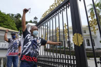 Supporters of former Malaysian Prime Minister Najib Razak shout slogans while raising their hands outside the former leader's residence in Kuala Lumpur, Malaysia, Wednesday, Dec. 8, 2021. Malaysia's Appeal Court has upheld the conviction of ex-Prime Minister Najib Razak linked to the massive looting of the 1MDB state investment fund that brought down his government in 2018. (AP Photo/Vincent Thian)