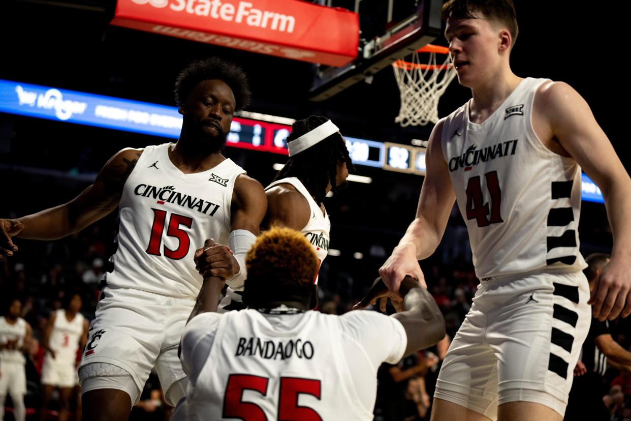 Cincinnati Bearcats forward John Newman III (15) and Cincinnati Bearcats guard Simas Lukosius (41) help up Cincinnati Bearcats forward Aziz Bandaogo (55) after he is fouled in the second half of the NCAA Basketball game between the Bryant Bulldogs and Cincinnati Bearcats at Fifth Third Arena in Cincinnati on Tuesday, Dec. 12, 2023.