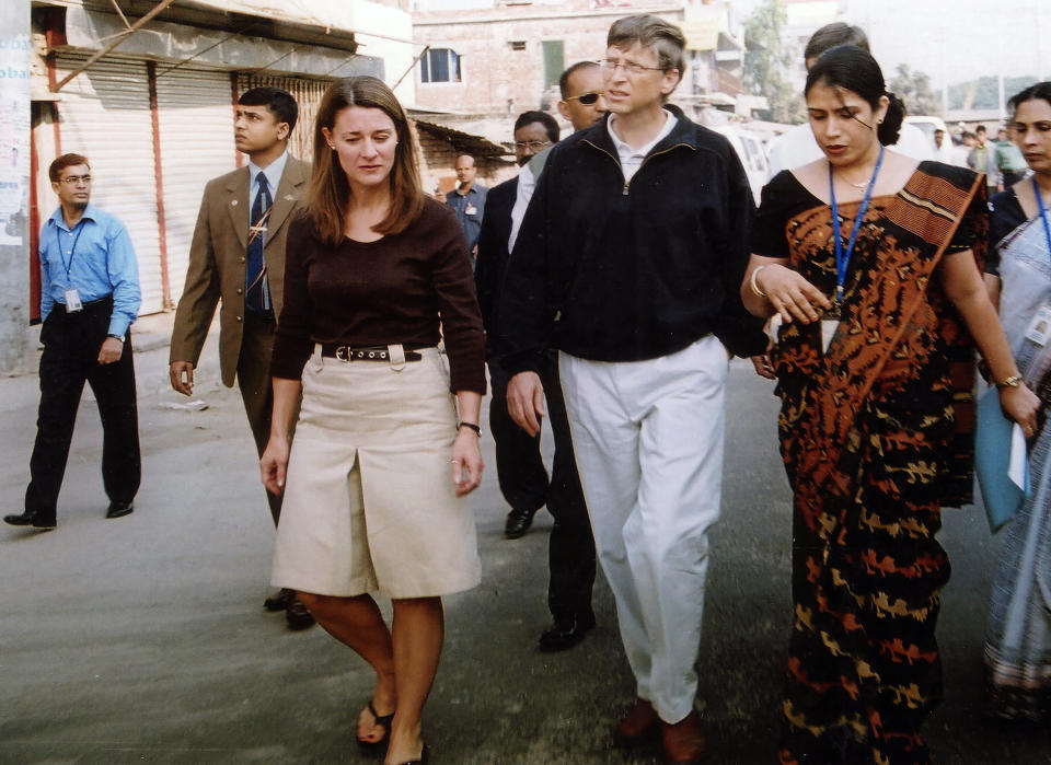 FILE - In this Dec. 5, 2005, file photo, Bill Gates, founder and chairman of Microsoft Corp., center, and his wife Melinda, left, walk on a street in Dhaka, Bangladesh. The couple announced Monday, May 3, 2021, that they are divorcing. The Microsoft co-founder and his wife, with whom he launched the world's largest charitable foundation, said they would continue to work together at The Bill & Melinda Gates Foundation. (AP Photo/Gazi Sarwar, File)