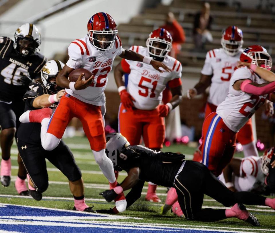 Mansfield defender David Hogg (9) brings own Duncanville quarterback Keelon Russell (12) after a short gain in the first half of a UIL high school football game at Vernon Newsom Stadium in Mansfield, Texas, Thursday, Oct. 12, 2023.