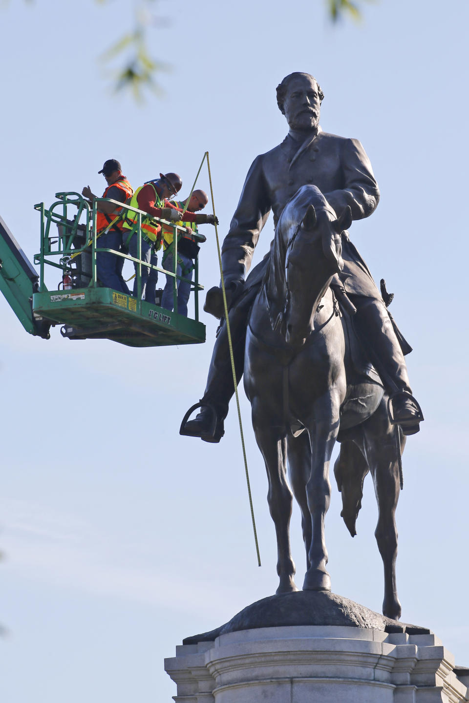 An inspection crew from the Virginia Department of General Services take measurements as they inspect the statue of Confederate Gen. Robert E. Lee on Monument Avenue Monday June 8, 2020, in Richmond, Va. Virginia Gov. Ralph Northam has ordered the removal of the statue. (AP Photo/Steve Helber)