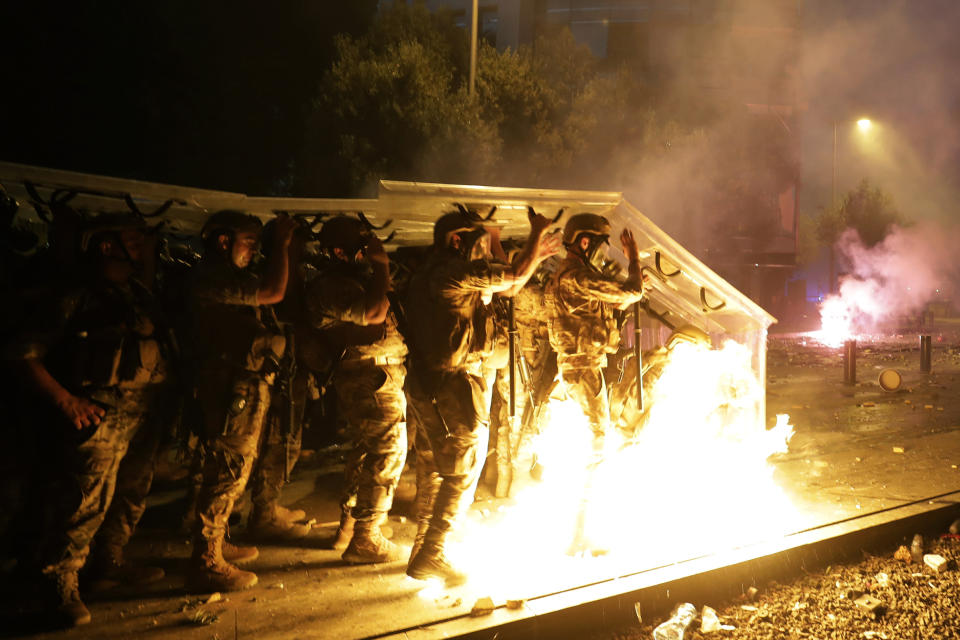 Molotov cocktails are hurled at Lebanese soldiers by anti-government protesters during a protest against the political elites and the government after this week's deadly explosion at Beirut port which devastated large parts of the capital in Beirut, Lebanon, Saturday, Aug. 8, 2020. (AP Photo/Hassan Ammar)