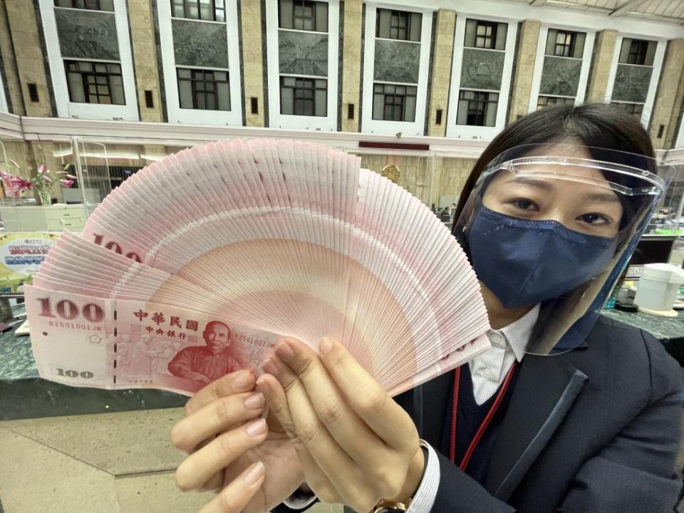 農曆新年即將到來，台灣銀行二十四日起開放民眾臨櫃換新鈔，但排隊換鈔民眾比往年少，因應疫情升溫，行員皆穿戴好防護裝備，高規格防疫。（中央社）