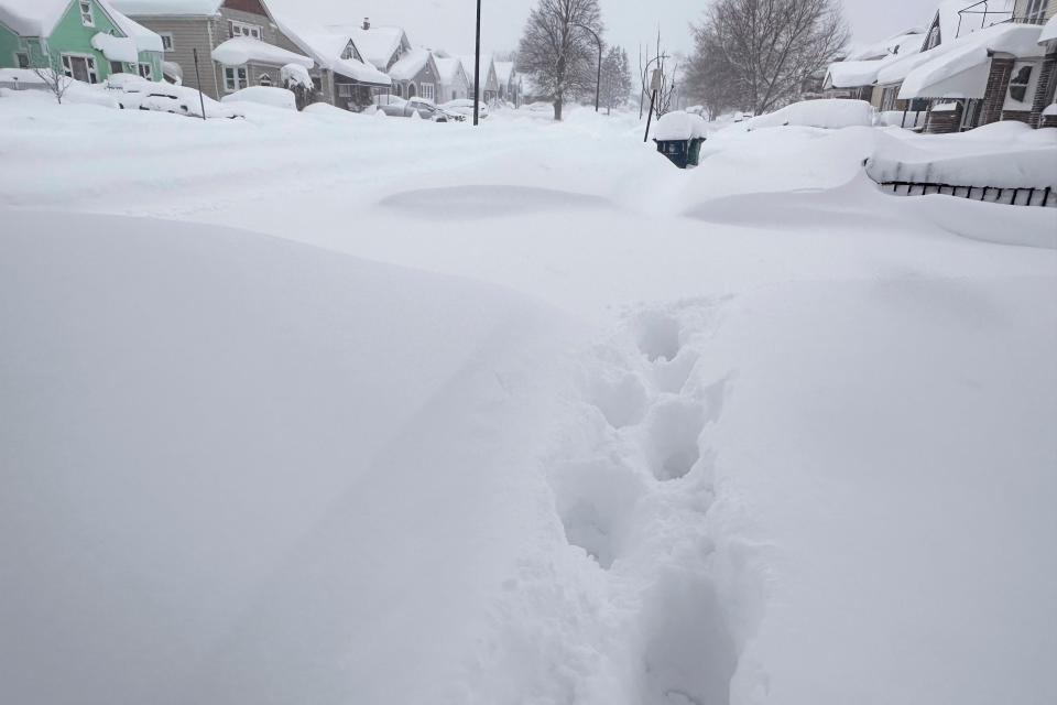 Footprints appear on a residential street after at least 18 inches of new snow fell overnight on Tuesday in Buffalo (AP)