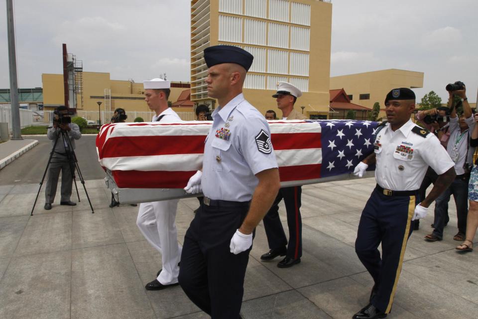 Four U.S. servicemen carry a coffin draped with U.S. national flag containing possible remains of a U.S. serviceman to a C-17 cargo plane during a repatriation ceremony at Phnom Penh International Airport, Cambodia, Wednesday, April 2, 2014. The possible remains of U.S. soldiers found in eastern Kampong Cham province were repatriated to Hawaii for testing. (AP Photo/Heng Sinith)