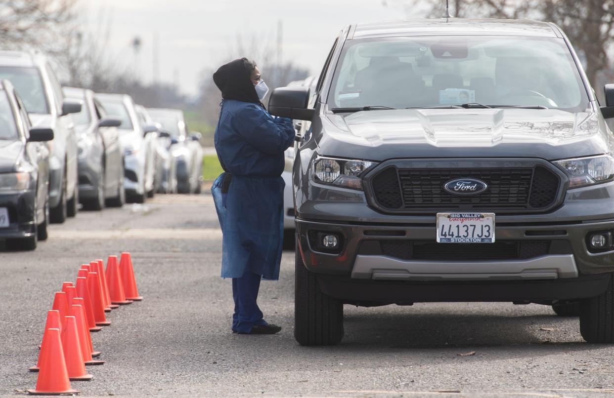 HR Support technicians perform COVID-19 tests on motorists at a free drive-up COVID testing site at Chavez High School in Stockton.