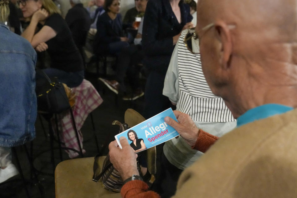 A supporter of Independent candidate for the inner city seat of Wentworth, Allegra Spender, holds a sticker with her photo at a public forum ahead of next weekend's general election in Sydney, Australia on May 16, 2022. Australia's government, considered a laggard on combating climate change, faces a new threat in the form of highly-organized and well-funded independent election candidates who demand deeper cuts on greenhouse gas emissions. (AP Photo/Mark Baker)