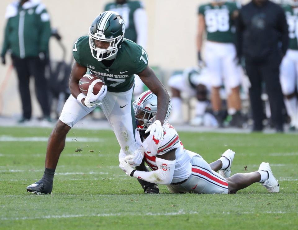 Michigan State Spartans wide receiver Tre Mosley (17) is tackled by Ohio State Buckeyes safety Tanner McCalister (15) during first half action at Spartan Stadium Saturday, October 8, 2022.