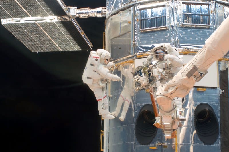 Astronauts John Grunsfeld (L) and Andrew Feustel work on the Hubble Space Telescope in the cargo bay of the Earth-orbiting Space Shuttle Atlantis on May 14, 2009. The mission specialists performed the first of five STS-125 spacewalks and the first of three for this duo. NASA/UPI