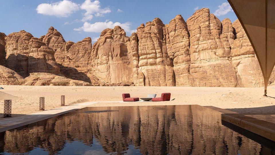 Dos asientos y una mesa dispuestos en mitad del desierto en el valle de AlUla