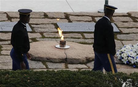 Members of the Armed Forces Color Guard visit at Arlington National Cemetery mark the 50th anniversary of the assassination of former U.S. President John F. Kennedy, at his gravesite in Arlington, November 22, 2013. REUTERS/Larry Downing