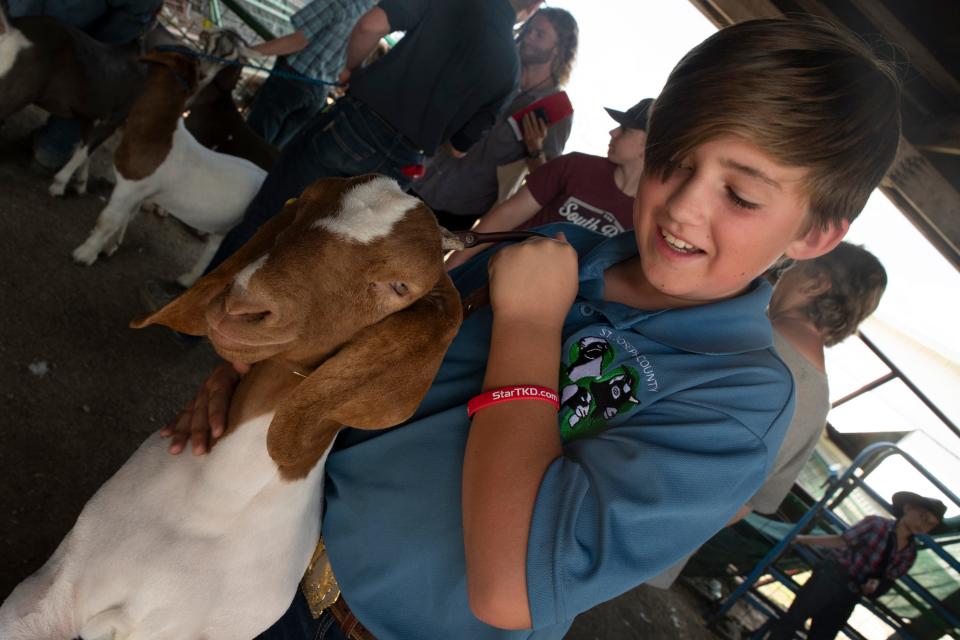 Marquis Clark, 12, holds his goat while he waits to auction it off at the Nilus Arena at the St. Joseph County 4-H Fair on Friday, July 7, 2023.