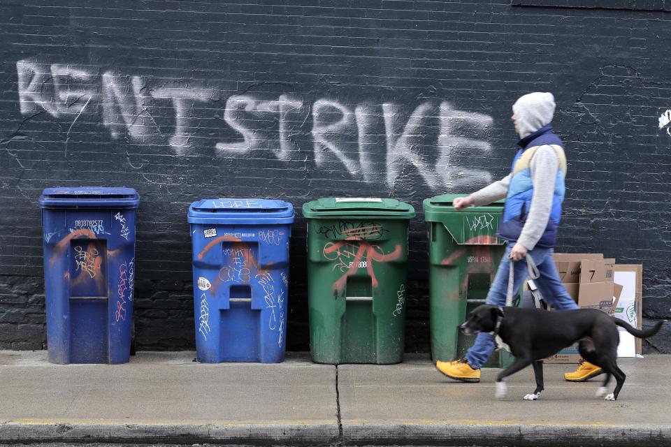 A pedestrian walks past graffiti that reads 