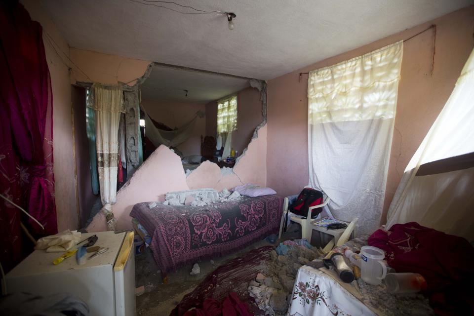 A bed is covered by rubble from a wall that collapsed during a magnitude 5.9 earthquake the night before, in Gros Morne, Haiti, Sunday, Oct. 7, 2018. Emergency teams worked to provide relief in Haiti on Sunday after the quake killed at least 11 people and left dozens injured. ( AP Photo/Dieu Nalio Chery)