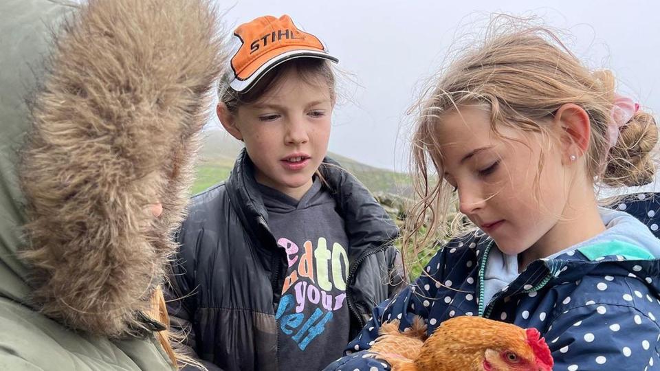 Amanda Owen's children and a chicken at their family farm