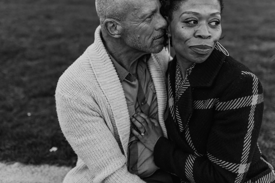 Black-and-white image of seated older couple embracing