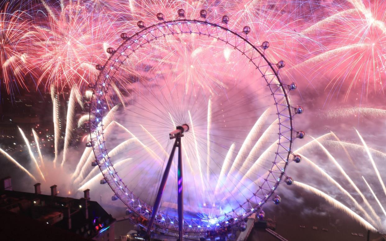 Fireworks light up the sky over the London Eye in central London during the New Year celebrations - PA