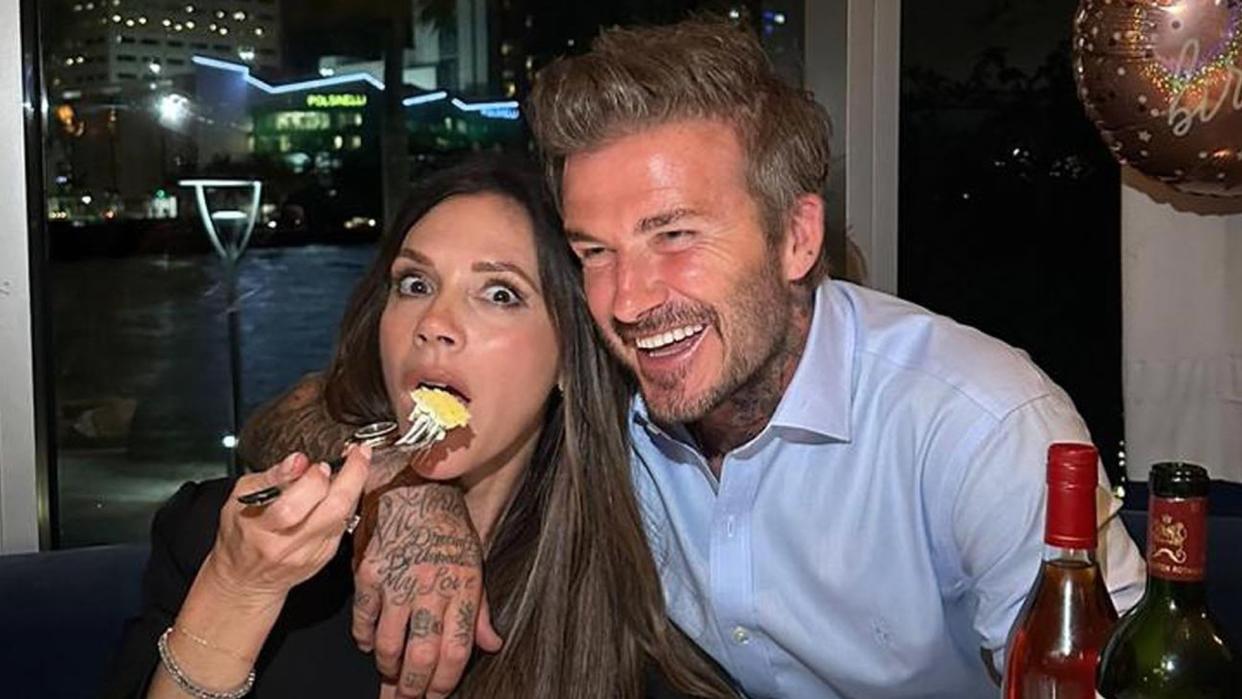 Victoria Beckham eating cake beside her husband David Beckham