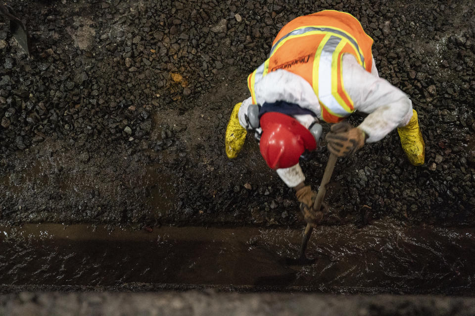 Amtrak workers perform tunnel repairs to a partially flooded train track bed, Saturday, March 20, 2021, in Weehawken, N.J. With a new rail tunnel into New York years away at best, Amtrak is embarking on an aggressive and expensive program to fix a 110-year-old tunnel in the interim. (AP Photo/John Minchillo)