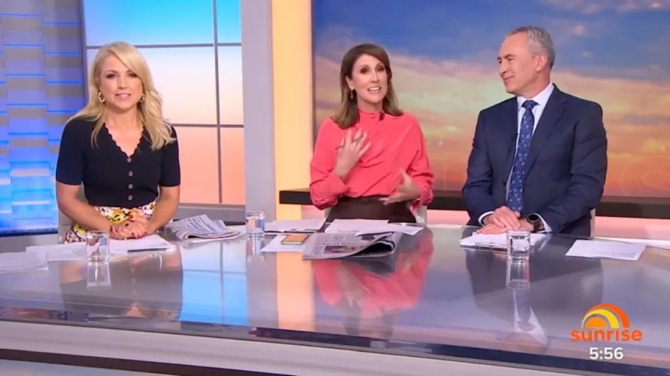 Natalie Barr, Monique Wright and Mark Beretta sit at the Sunrise desk. Natalie is wearing a bright salmon coloured top